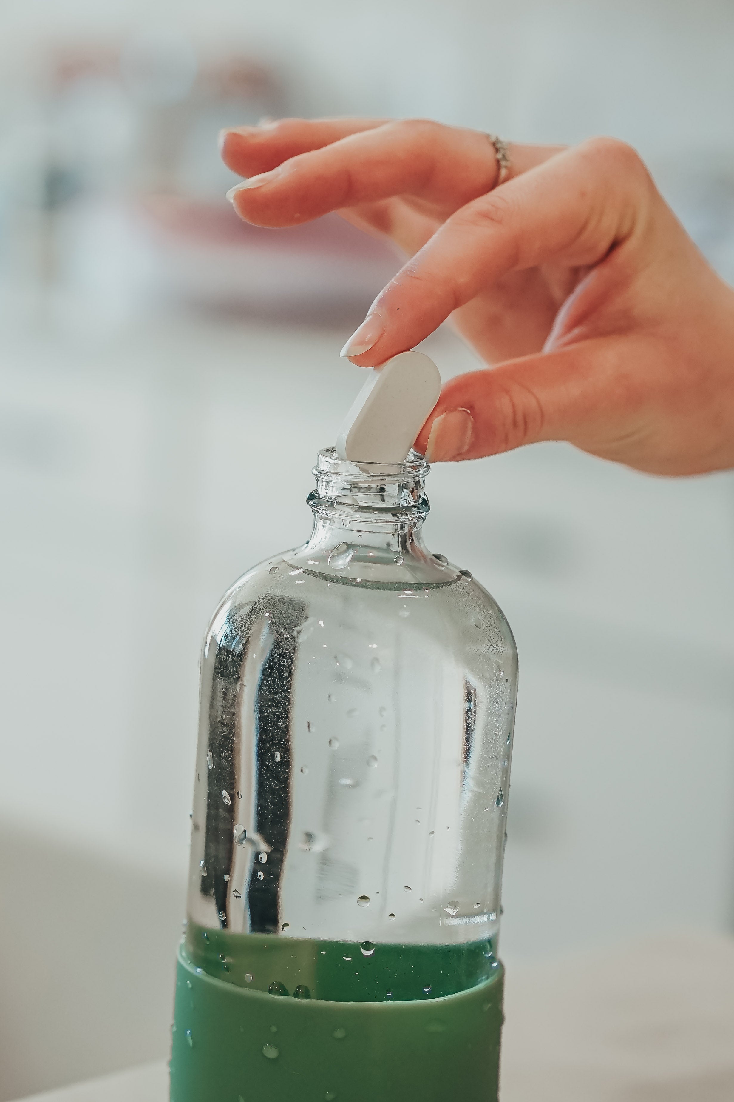 Dropping multi purpose cleaning tablets into a bottle for get safely cleaning results.