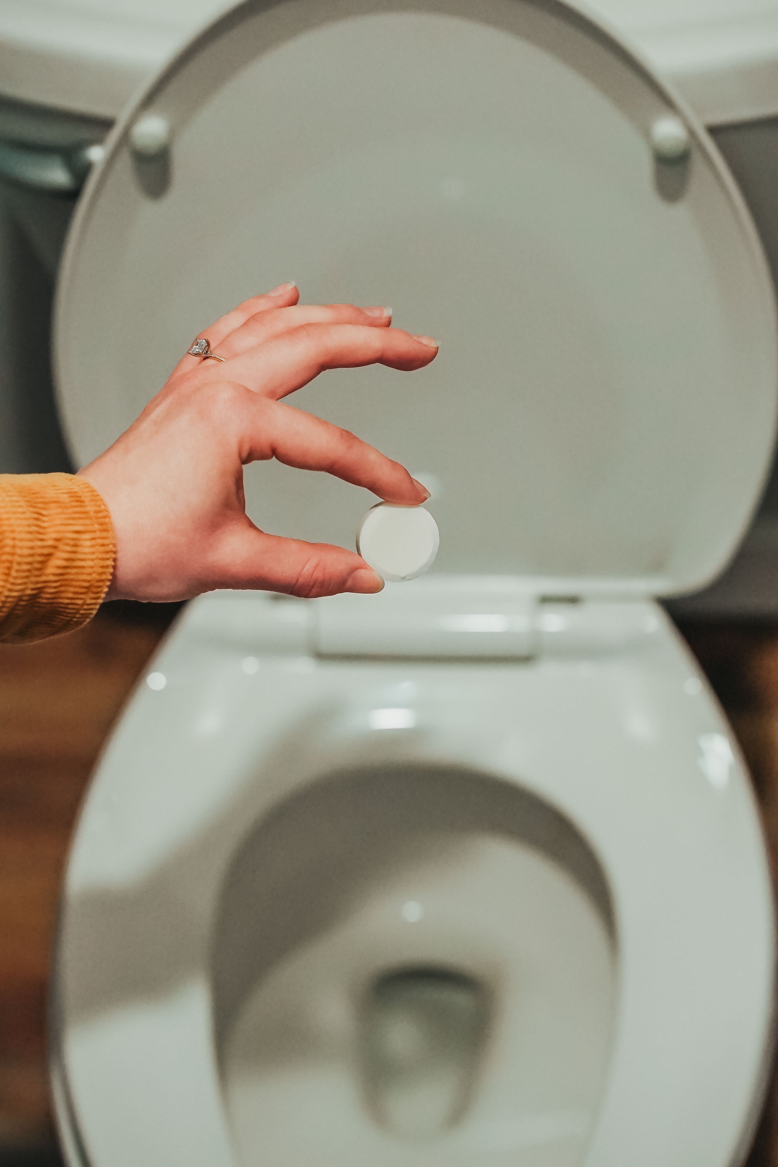 Holding a Cleaning Bomb, part of a natural cleaning product and bathroom cleaner bomb kit, safe, eco-friendly, and effective toilet cleaner bomb solution for home cleaning.