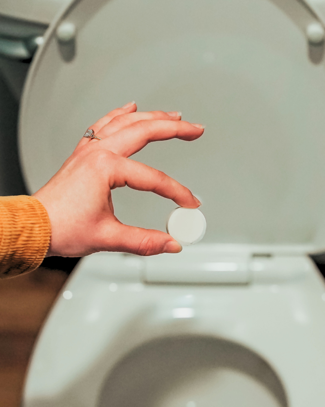 Holding a Cleaning Bomb, part of a natural cleaning product and bathroom cleaner bomb kit, safe, eco-friendly, and effective toilet cleaner bomb solution for home cleaning.