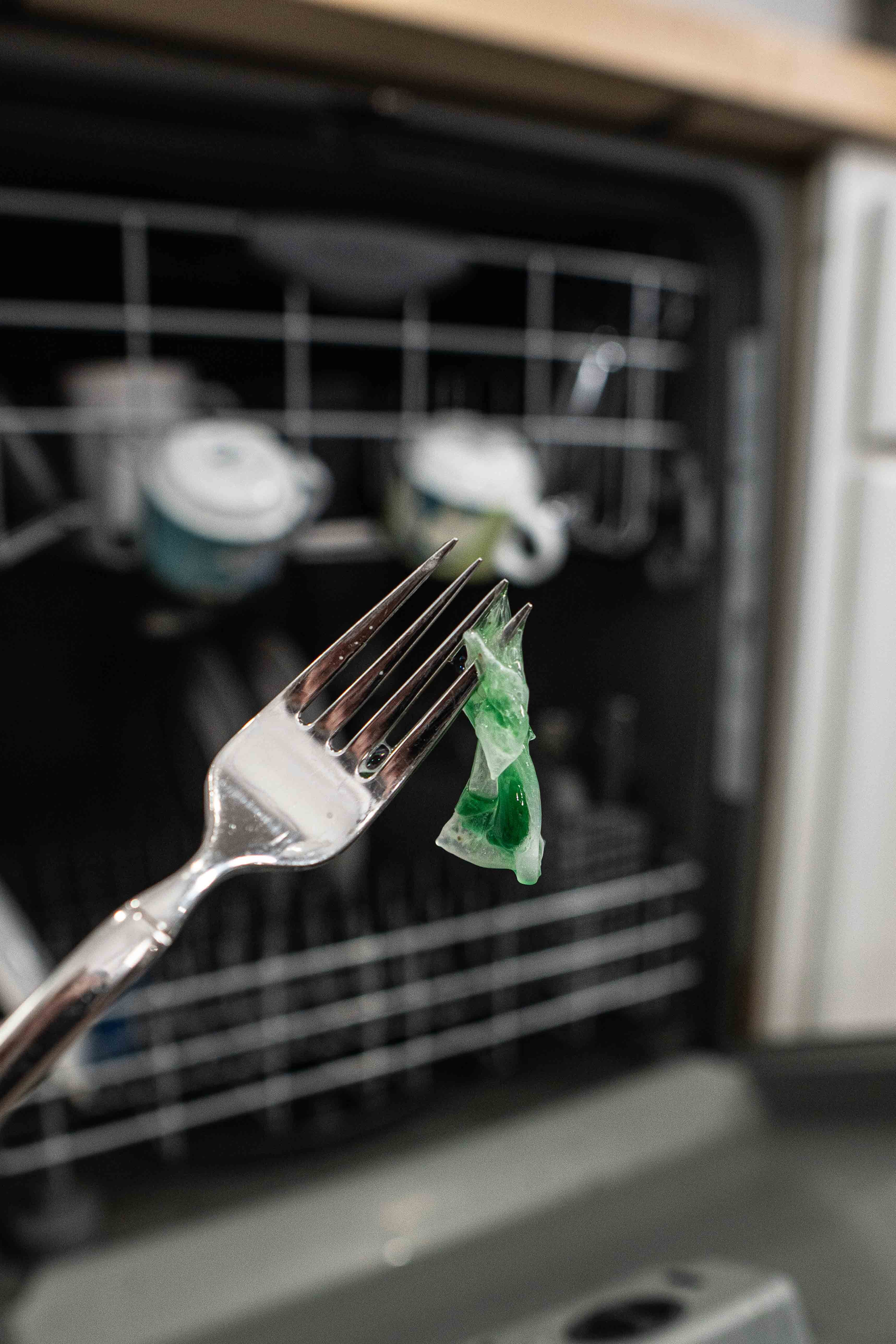 Residue from traditional dishwasher pods compared to streak-free Dishwasher Sheets, a plant-based natural cleaning product.